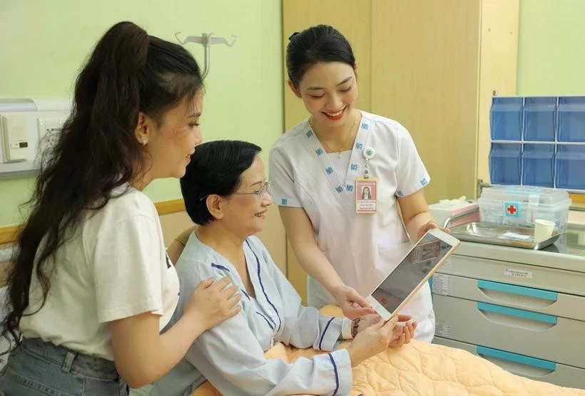 A medical worker at the University Medical Centre Ho Chi Minh City use tablets to update and share information with a patient. (Photo: VNA)