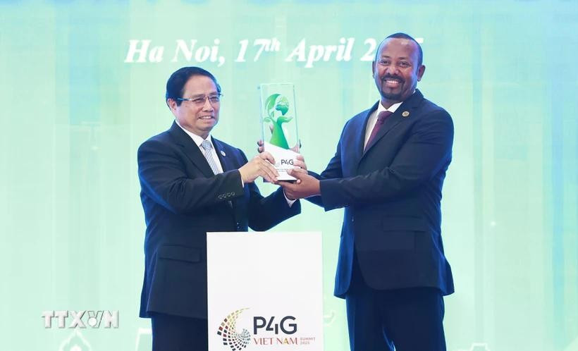 Prime Minister Pham Minh Chinh (left) hands over the logo of hosting the fifth Partnership for Green Growth and the Global Goals (P4G) Summit to Ethiopian Prime Minister Abiy Ahmed Ali. (Photo: VNA)