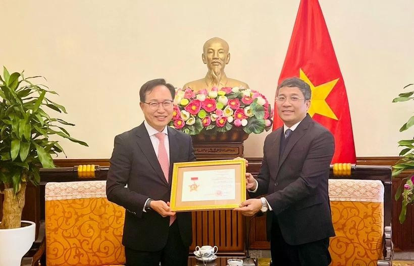 Permanent Deputy Minister of Foreign Affairs Nguyen Minh Vu (right) awards the For the Cause of Vietnam’s Foreign Affairs insignia to General Director of Samsung Vietnam Choi Joo Ho on February 13. (Photo: VNA)