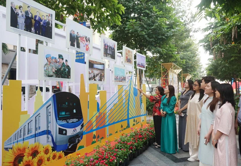 Visitors look at photos at an exhibition which highlights glorious milestones of the Communist Party of Vietnam (Photo: VNA)