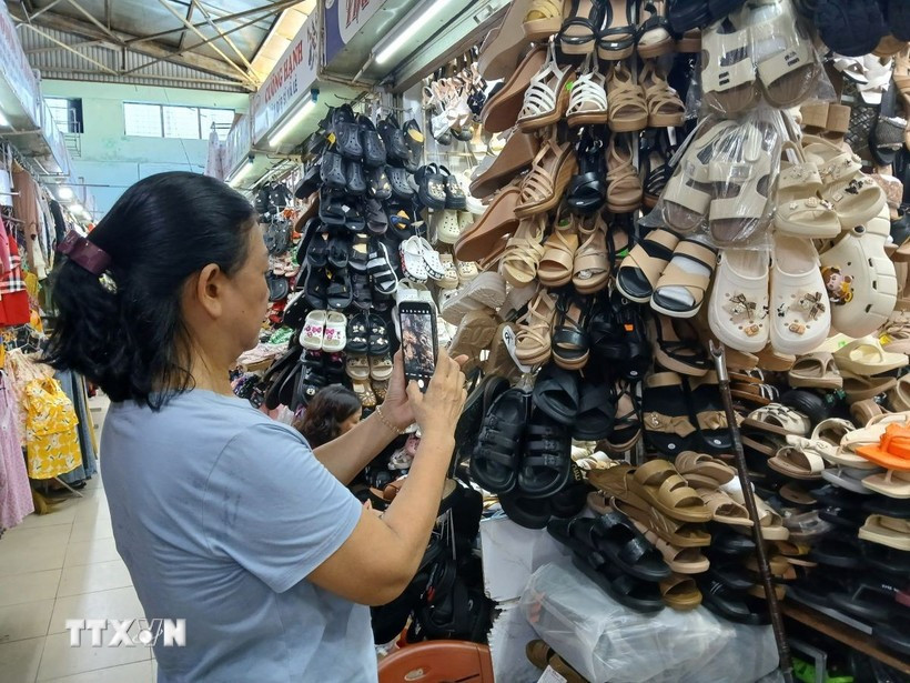 Traders at Dong Da market in Da Nang city use Zalo to sell online. (Photo: VNA)