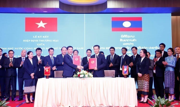 Minister of Industry and Trade Nguyen Hong Dien and his Lao counterpart Malaithong Kommasith sign the Vietnam - Laos Trade Agreement on April 8, 2024. (Photo: VNA)
