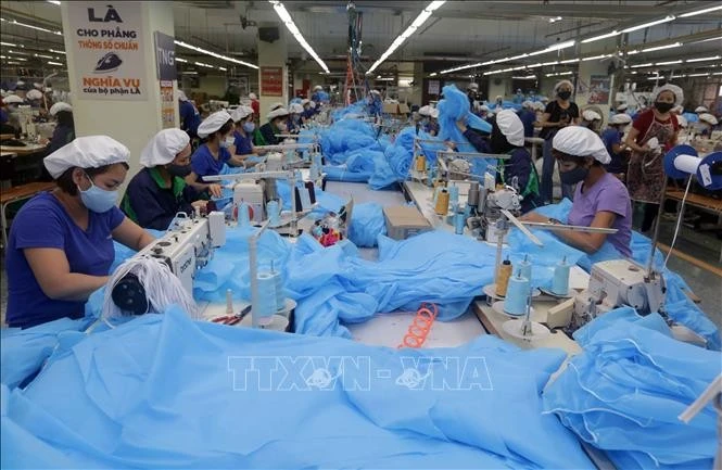 Processing protective suits and medical masks for export to the Czech Republic. (Photo: VNA)