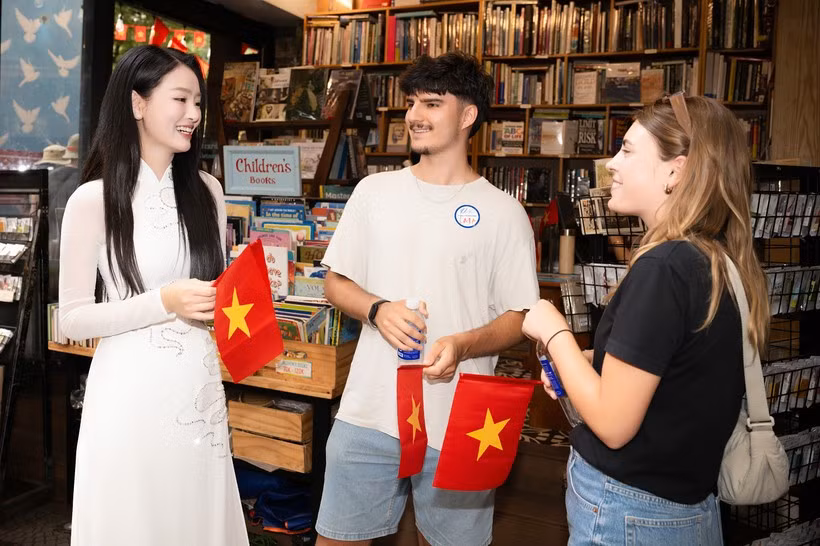 International tourists are excited to receive a red flag with a yellow star while visiting Ho Chi Minh City. (Photo: VietnamPlus)