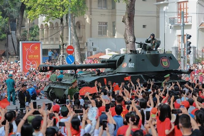 The formations of tanks and armoured vehicles are welcomed by crowds. (Photo: VNA)