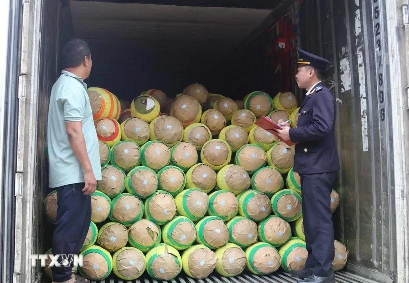 Customs officials check agricultural products before exporting at Huu Nghi Border Gate in Lang Son province (Photo: VNA)