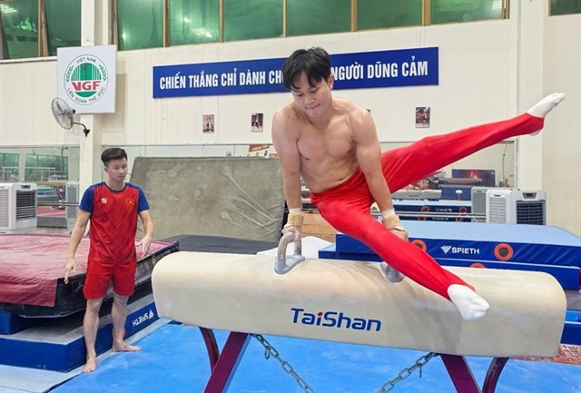 Nguyen Van Khanh Phong trains under the watchful eye of his coach. Vietnam is hoping to defend many titles in the 33rd SEA Games. (Photo: nhandan.vn)