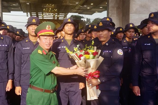 Colonel Nguyen Dinh Chuan, Political Commissar of the Binh Duong provincial Military Command (left), presents flowers to the Cambodian delegation. (Photo: VNA)