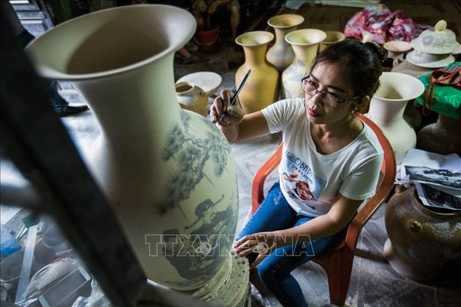 A worker creates patterns for Bat Trang ceramic products. (Photo: VNA)