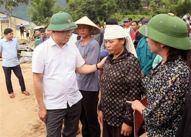 Deputy PM Le Thanh Long offers encouragement to families affected by floods and landslides. (Photo: VNA)
