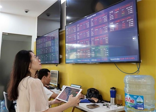 Investors watch the market's movements at a trading office of a securities firm. (Photo: VNA) 