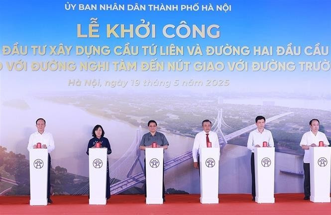 Prime Minister Pham Minh Chinh (3rd from left) at the symbolic button-pressing ceremony to kick off the construction of the Tu Lien bridge in Hanoi on May 19. (Photo: VNA)