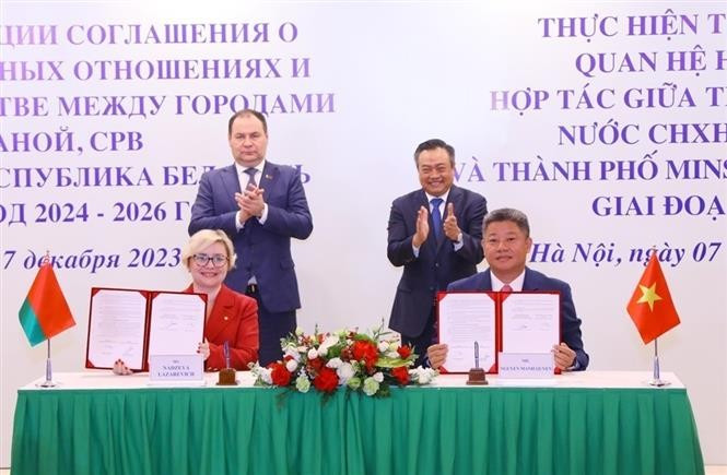 Belarusian Prime Minister Roman Golovchenko (standing, left) and Chairman of the Hanoi People's Committee Tran Sy Thanh witness the signing of the cooperation programme to implement the agreement on friendship and cooperation between Hanoi and Minsk in 2023. (Photo: VNA)