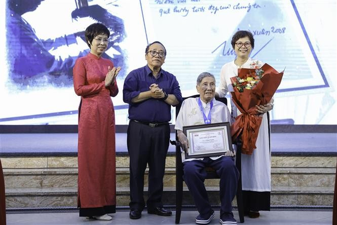 VNA General Director Vu Viet Trang (first, left) presents the Cricket Knight Award to composer Pham Tuyen (sitting) at the ceremony. (Photo: VNA)
