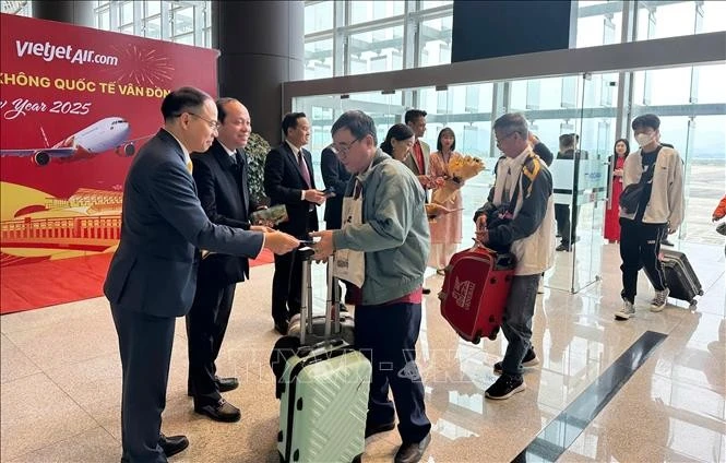 Representatives from Quang Ninh's Van Don district and Tourism Department welcome and give lucky money to visitors at Van Don airport. (Photo: VNA)