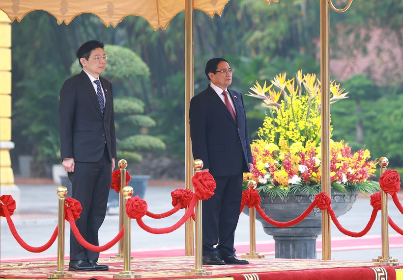 Prime Minister Pham Minh Chinh (R) and his Singaporean counterpart Lawrence Wong stand for the national anthems of Vietnam and Singapore. (Photo: VNA)