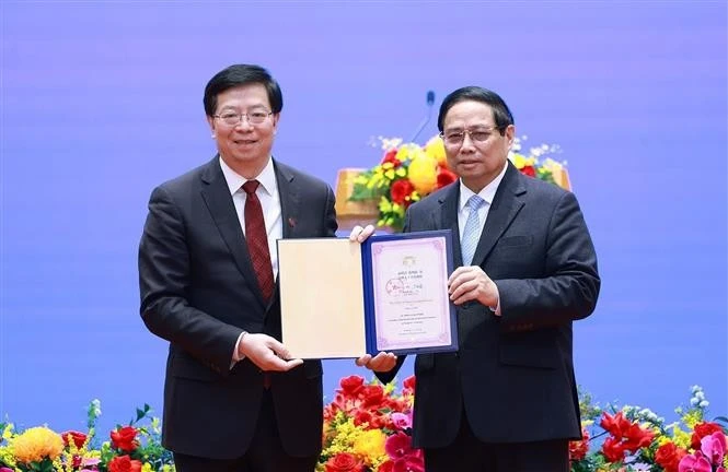 Prof. Dr. Qiu Yong (L), Secretary of the Tsinghua University’s Party Committee and Academician of the Chinese Academy of Sciences presents the "Honorary Professor" title to PM Pham Minh Chinh. (Photo: VNA)