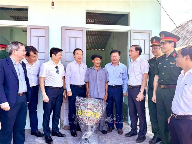 Members of the Steering Committee for the Elimination of Temporary and Dilapidated Houses in Quang Tri province visit and present gifts to a poor household in Huong Hoa district who received support to build a new house. (Photo: VNA)