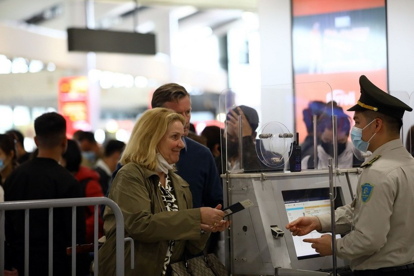 An aviation security official checks passenger information before security screening. (Photo: VNA)