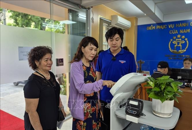 Citizens use AI-powered robot at the Cua Nam ward public service centre. (Photo: VNA)