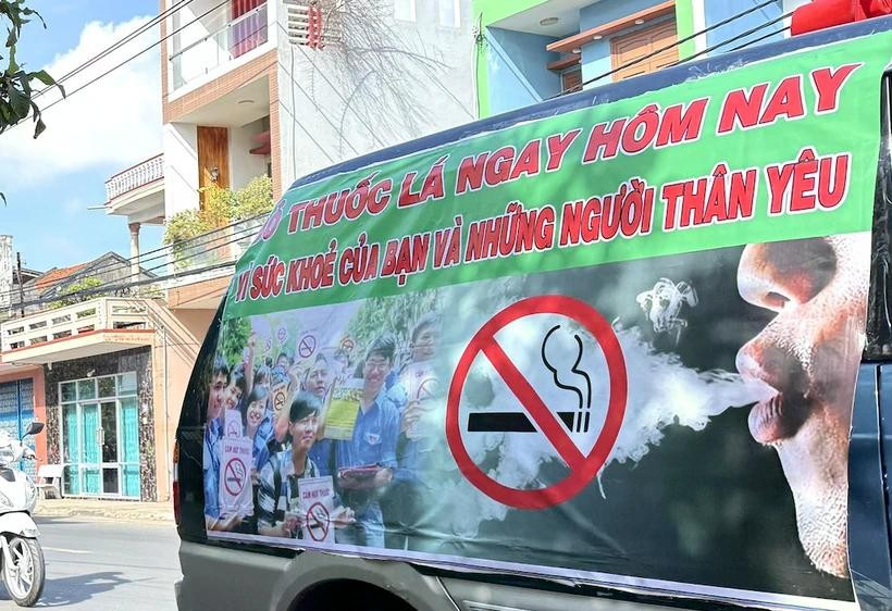 A banner on the side of a car urges people to quit smoking for their own health and that of their loved ones (Photo: VNA)