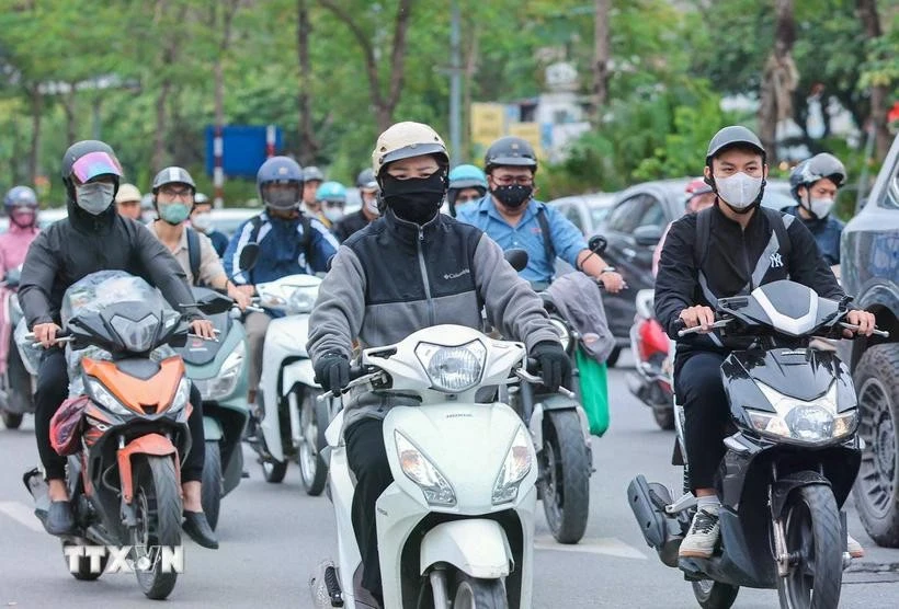 Motorcyclists wear warm clothes and gloves when traveling outdoors (Photo: VNA)