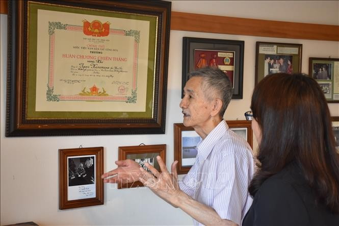 Phan The Vong introduces his father's memorabilia. (Photo: VNA)