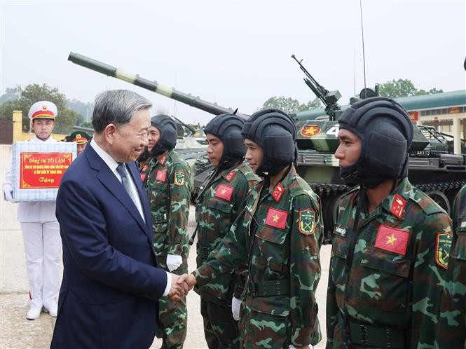 Party General Secretary To Lam, Secretary of the Central Military Commission, shakes hands with a serviceman of the Tank-Armored Corps. (Photo: VNA)