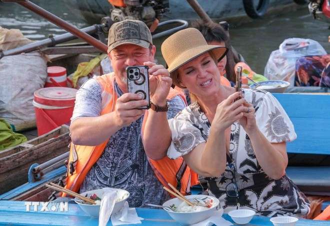 Foreign tourists experience floating market in Can Tho (Photo: VNA)