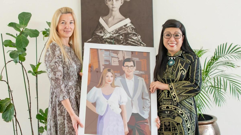 Vietnamese PM’s spouse (R) presents a mosaic to Estonian PM’s wife. (Photo: VNA)