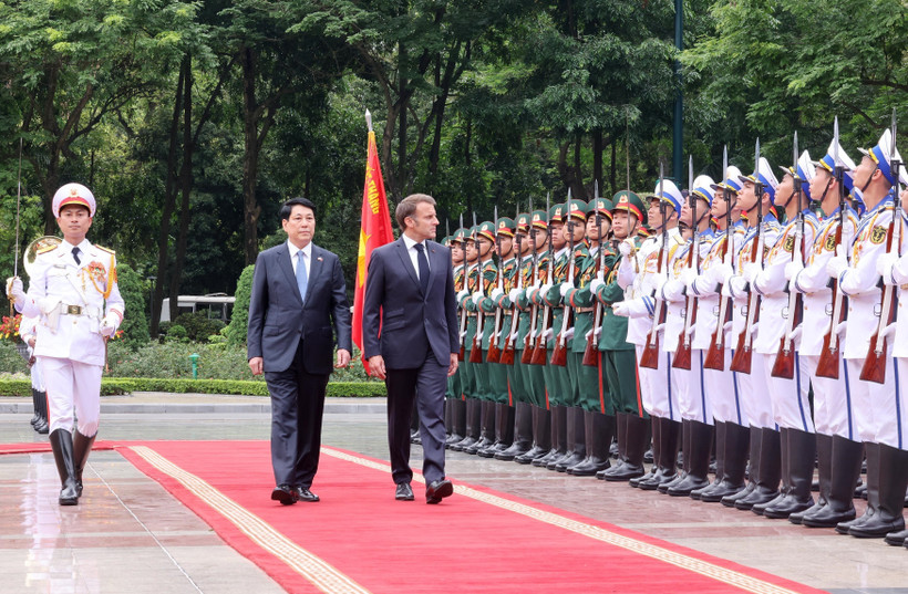 State President Luong Cuong (left) and French President Emmanuel Macron review the Guard of Honour of the Vietnam People’s Army. (Photo: VNA)