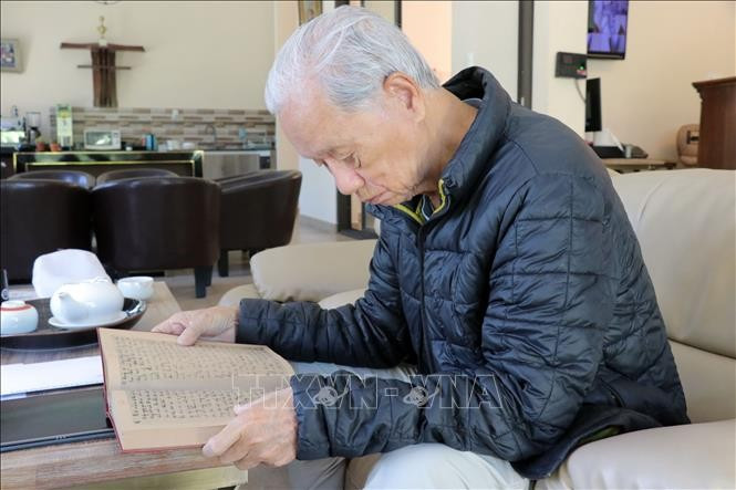 Nghiem Sy Thai, the former war reporter of the Liberation Press Agency, reads his diary. (Photo: VNA)
