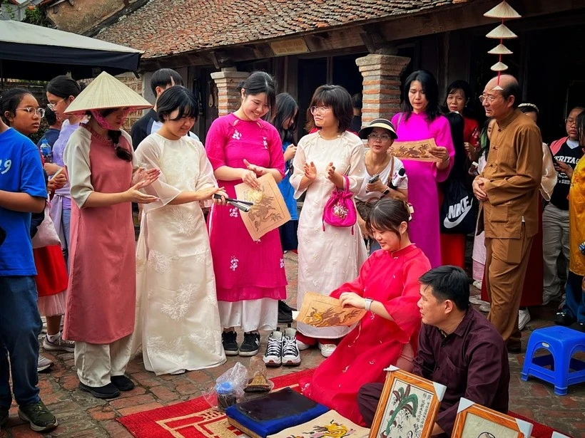 Korean tourists immerse themselves in Dong Ho folk paintings in Duong Lam ancient village, Hanoi (Photo: VNA)