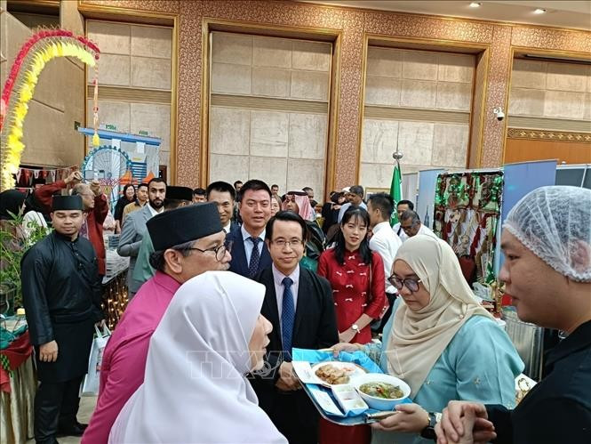 Vietnamese Ambassador to Brunei Tran Anh Vu introduces 'pho' and 'nem ran' to a Brunei official (Photo: VNA)