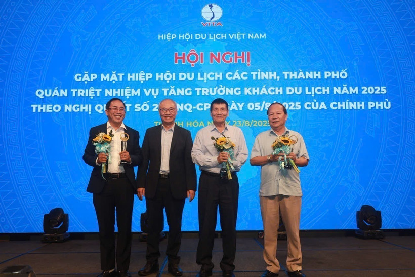 VITA Chairman Vu The Binh presents certificates of merit and insignias to units and individuals for contributions to tourism industry (Photo: VNA)