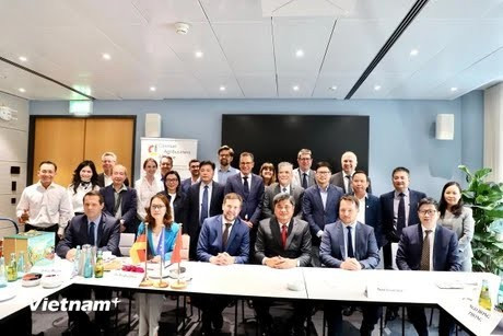 Deputy Minister Tran Thanh Nam (front line, in a red tie) takes a photo with representatives of German associations and businesses at the event. (Photo: VNA)