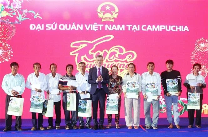 Vietnamese Ambassador to Cambodia Nguyen Minh Vu (middle) presents Tet gifts to representatives of poor households in Cambodia. (Photo: VNA)