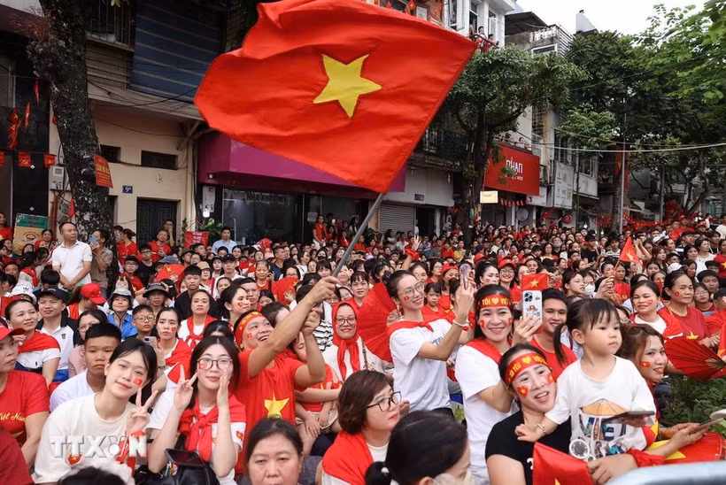 People happily welcome the forces joining in a rehearsal for the National Day parade. (Photo: VNA)