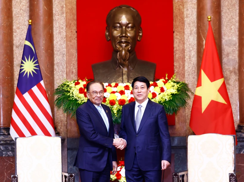 Vietnamese State President Luong Cuong (R) welcomes Malaysian Prime Minister Anwar Ibrahim. (Photo: VNA)