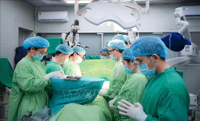 Doctors observe a minute of silence to pay tribute to the organ donor. (Photo: published by VNA)