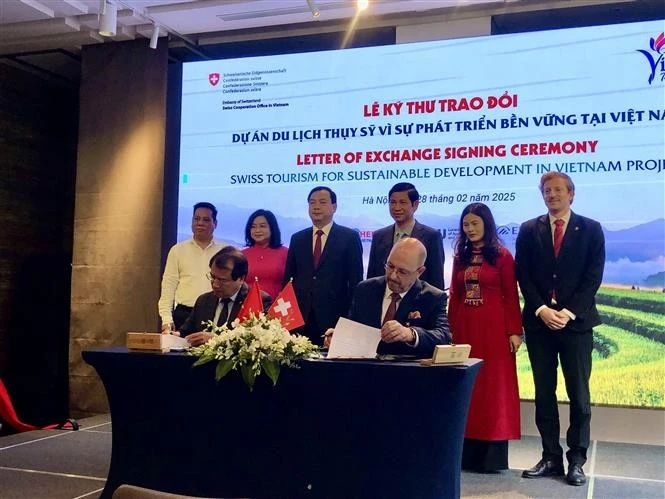 Swiss Ambassador to Vietnam Thomas Gass and Deputy Director of the Vietnam National Authority of Tourism Ha Van Sieu sign a Letter of Exchange. (Photo: VNA)