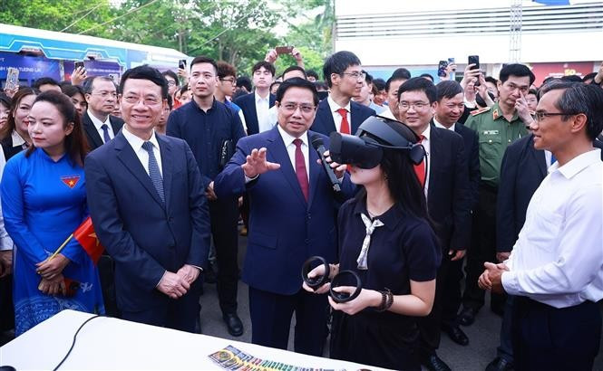 PM Chinh and other delegates visit exhibition areas showcasing innovative and digital transformation products of universities and businesses. (Photo: VNA)