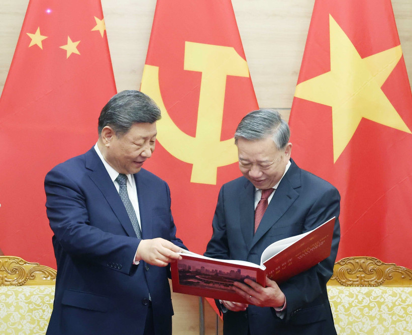 Party General Secretary To Lam (right) presents Party General Secretary and President of China Xi Jinping a photo book by the Vietnam News Agency featuring typical and impressive photos of Xi's five visits to Vietnam since 2011 (Photo: VNA)