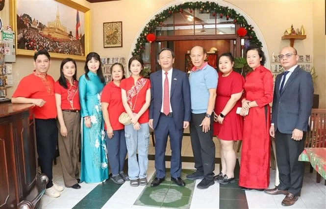 From right: Ambassador Nguyen Minh Tam (5th from right) and the family of Le Dung, former president of the Vietnamese Association in Vientiane. (Photo: VNA)