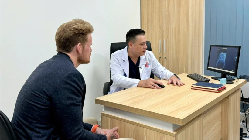 D.F (left), a US patient, at a follow-up examination with Do Lenh Hung, head of the department of urethral reconstructive surgery. (Photo: VNA)