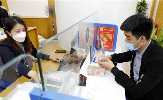 A customer conducts transactions at a bank in Hanoi. (Photo: VNA)
