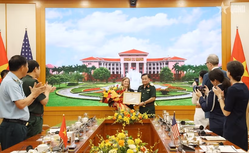 Deputy Defence Minister Senior Lieutenant General Hoang Xuan Chien (R) presents a certificate of merit from the Minister of National Defence of Vietnam to USAID's Mission Director for Vietnam Aler Grubbs (Photo: VNA)