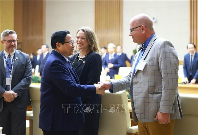 Prime Minister Pham Minh Chinh (L) receives representatives of 21 leading US universities, who are participating in the International Academic Partnership Programme (IAPP) in Vietnam. (Photo: VNA)