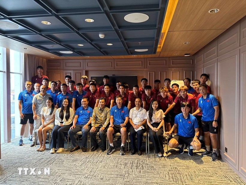 Ambassador Ta Van Thong (fourth, left, front row) staff of the Vietnamese Embassy, and the Vietnamese community in Indonesia pose for a group photo with the Vietnam U23 men's football team. (Photo: VNA)
