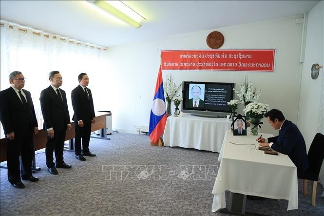 Ambassador Phan Manh Dung, who led a delegation from the Permanent Mission of Vietnam in Geneva, writes on the condolence book in commemoration of former Chairman of the Lao People's Revolutionary Party (LPRP) Central Committee, former President and former Prime Minister of Laos Khamtay Siphandone. (Photo: VNA)